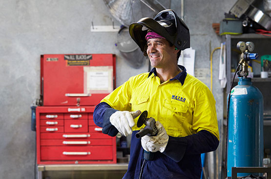 A Metro Steel Services team member holding an angle grinder